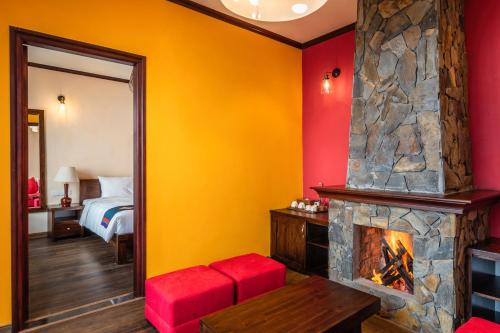 a hotel room with a fireplace and a bed at Cat Cat Galerie d’Art in Sa Pa