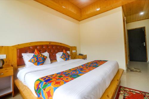 a bedroom with a large bed with a colorful comforter at FabHotel King XI Hospitalities in Manāli