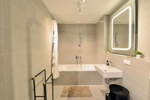 a bathroom with a sink and a bath tub at Brand-New, Close to Centre, Rooftop-Summer-Pool in Vienna