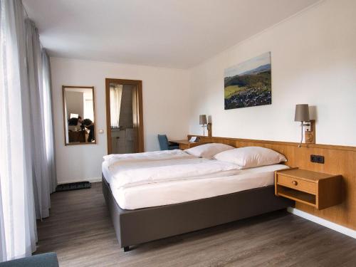 ein Schlafzimmer mit einem großen Bett in einem Zimmer in der Unterkunft Hotel Holländer Hof in Meschede