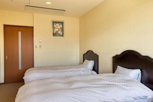 two beds sitting next to each other in a room at Fuji Matsuzono Hotel in Yamanakako