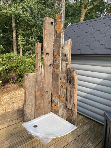 a wooden chair sitting on top of a deck at Luxe Finse Kota met Jacuzzi en SaunaBarrel de Zandhoef in Eersel