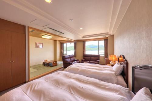a hotel room with two beds and a mirror at Fuji Matsuzono Hotel in Yamanakako