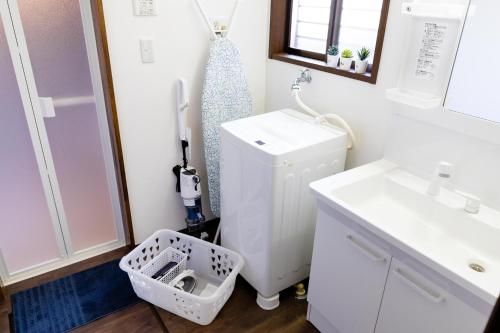 a bathroom with a sink and a white refrigerator at Wave House Kujukuri Shimokaizuka Beachside - Self Check-In Only in Kujukuri