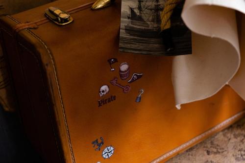 a brown suitcase with stickers on the side of it at Wave House Kujukuri Shimokaizuka Beachside - Self Check-In Only in Kujukuri