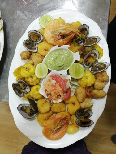 a plate of food with seafood and other foods at Hosteria B y B in Tonsupa