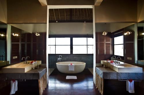 a large bathroom with two sinks and a large tub at Villa Melissa in Canggu