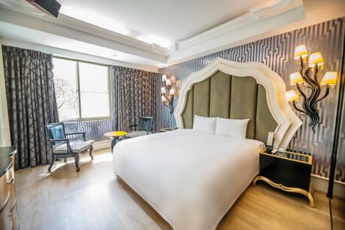 a bedroom with a large white bed and a chair at Region Motel in Lugang