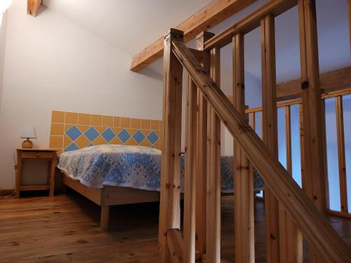 1 dormitorio con 1 cama y escalera de madera en Le Cocardier, en Saintes-Maries-de-la-Mer