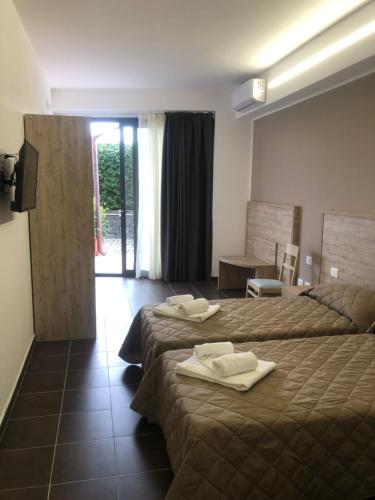 a hotel room with two beds with towels on them at Atlantis Palace Hotel in Mascali