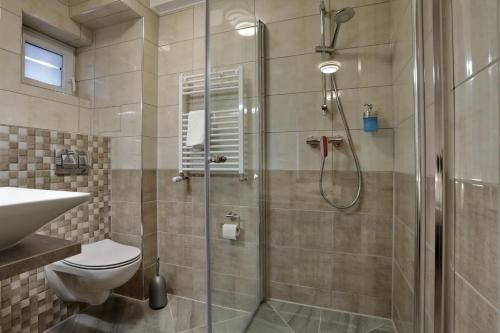 ein Bad mit einer Dusche, einem WC und einem Waschbecken in der Unterkunft Hotel am Park in Braunschweig