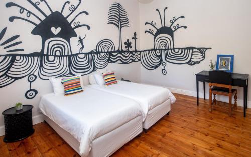 a bedroom with two beds and a desk and a piano at Villa Viva Cape Town in Cape Town