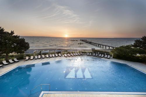 a large swimming pool with a view of the ocean at Maritim Seehotel Timmendorfer Strand in Timmendorfer Strand