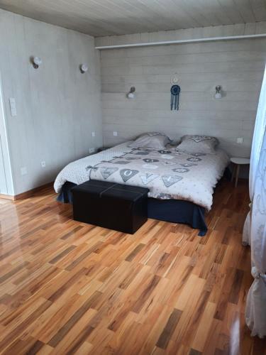 a bedroom with a bed and a wooden floor at La Vieille Fermette in Obersaasheim