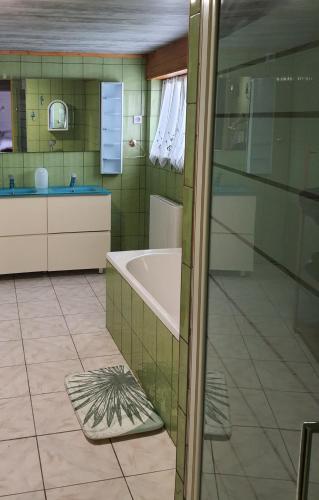 une salle de bain avec une baignoire et un lavabo dans l'établissement La Vieille Fermette, à Obersaasheim
