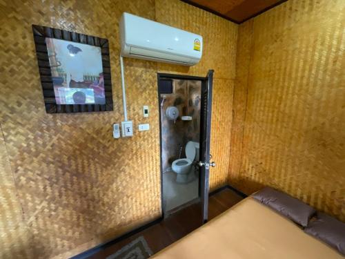 a small bathroom with a toilet and a mirror at ภูน้ำทิพย์ รีสอร์ท in Ban Huai Phai
