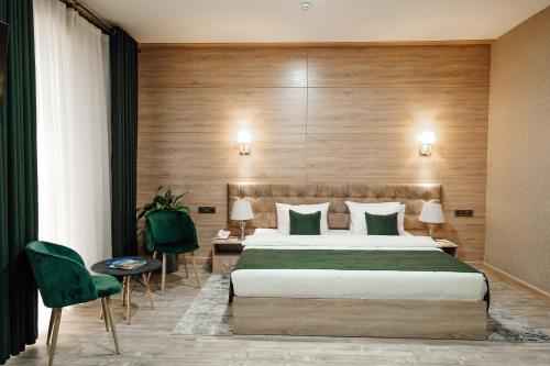 um quarto de hotel com uma cama e duas cadeiras em Central Palace Halal Hotel em Tashkent