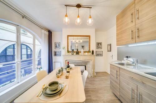 une cuisine avec une table à manger et une cheminée dans l'établissement Stunning Historical Parisian Flat - Louvre Area, à Paris