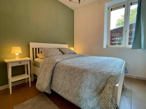 um quarto com uma cama e uma janela em L'appartement d'houyet - Esc'Appart em Houyet