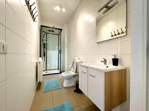 uma casa de banho branca com um lavatório e um WC em L'appartement d'houyet - Esc'Appart em Houyet