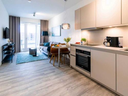eine Küche und ein Wohnzimmer mit einem Tisch und einem Sofa in der Unterkunft Hafenspitze App. 25 in Wismar