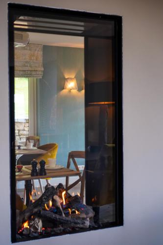 a mirror reflection of a living room with a fireplace at Les Terrasses des Falizes B&B in Rochefort