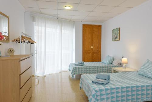 a room with two beds and a dresser in it at Casa Bonaire in Jávea