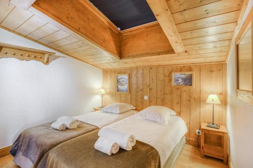 阿克1800Résidence Le Roselend - maeva Home的一间木墙房间里有两张床