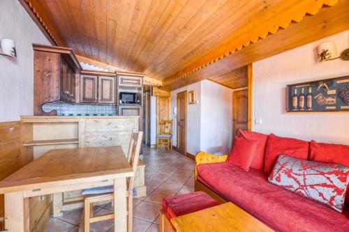 un salon avec un canapé rouge et une table dans l'établissement Résidence Le Roselend - maeva Home, à Arc 1800