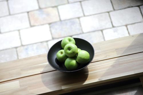 a bowl of green apples sitting on a table at Schieners Hotel & Apfelhof Apartments in Wemding