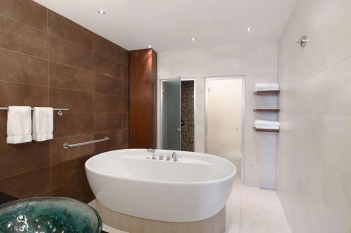 
a bathroom with a tub, sink and mirror at Radisson Blu Carlton Hotel, Bratislava in Bratislava
