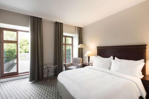 um quarto de hotel com uma cama grande e uma janela em Radisson Blu Carlton Hotel, Bratislava em Bratislava