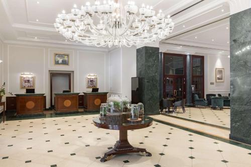 a large lobby with a chandelier and a table at Radisson Blu Carlton Hotel, Bratislava in Bratislava