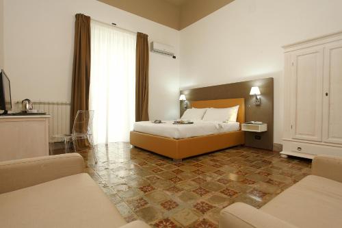 a hotel room with a bed and a couch at Casa Vacanze Woodhouse in Marsala