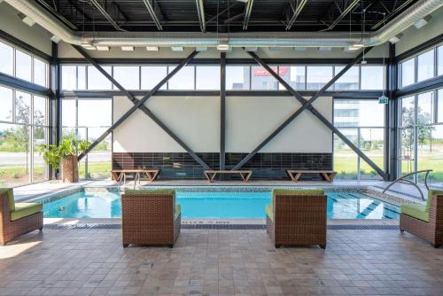 a large swimming pool with chairs and windows at Wingate by Wyndham Kanata West Ottawa in Ottawa