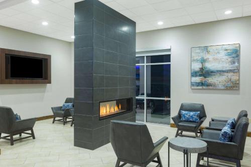 a lobby with a fireplace in a waiting room at La Quinta by Wyndham Joplin in Joplin