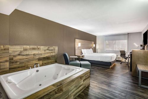 a hotel room with a large tub and a bed at La Quinta by Wyndham Joplin in Joplin
