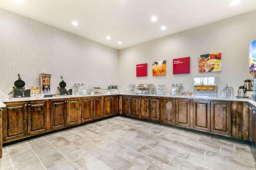 a large kitchen with wooden cabinets in a room at Comfort Suites North Tupelo in Tupelo