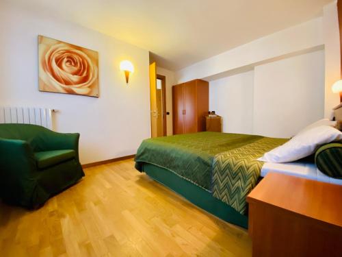 a hotel room with a bed and a chair at Residence Pizzo Scalino in Chiesa in Valmalenco