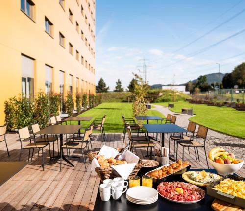 un buffet di cibi su un patio con tavoli e sedie di FIRMAMENT Hotel a Feldkirch