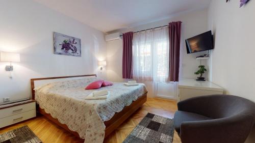 奧米什的住宿－Villa Ivanišević，一间卧室配有一张床、一把椅子和电视