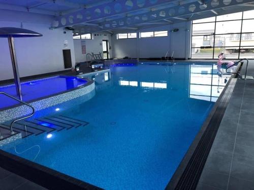 a large swimming pool with blue water in a building at Seldongoldengates in Kinmel Bay