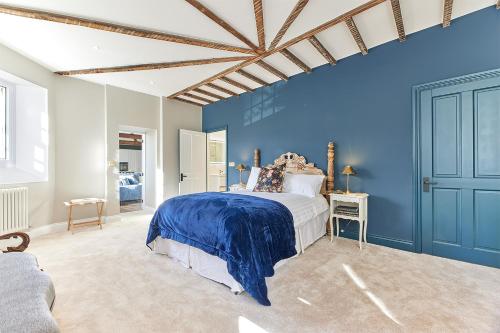 a blue bedroom with a bed and a blue wall at Host & Stay - The Old Workhouse in Alnwick
