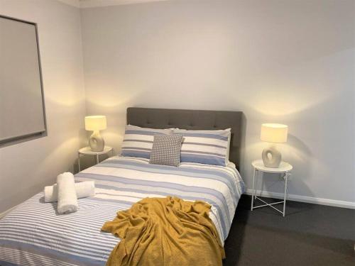 a bedroom with a bed with a blanket on it at MODERN CLOSE AIRPORT/SHOPS FREE NETFLIX WINE WIFI in Perth