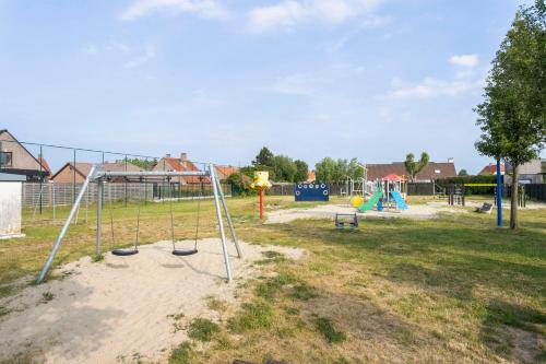 an empty park with a playground with swings at Vakantievilla met luxe en sauna in duinenreservaat in Koksijde