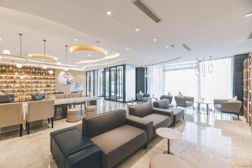 a lobby with couches and a bar in a building at Atour Hotel Kunshan Yongda Business Plaza in Kunshan