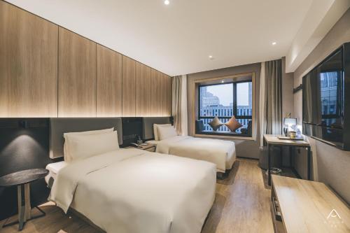 una camera d'albergo con due letti e una finestra di Atour Light Nanjing Xinjiekou NetEase CloudMusic a Nanjing