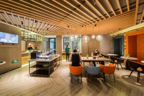a restaurant with people sitting at tables and a bar at Atour Light Harbin Central Street in Harbin