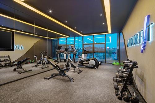 einen Fitnessraum mit mehreren Laufbändern und Crosstrainern in der Unterkunft Atour Hotel Yan'an Luyi Park in Yan'an