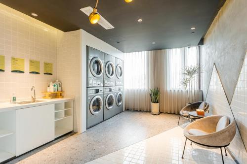a laundry room with four washing machines and a sink at Atour Hotel Jiaxing Haiyan Haifeng Road in Haiyan